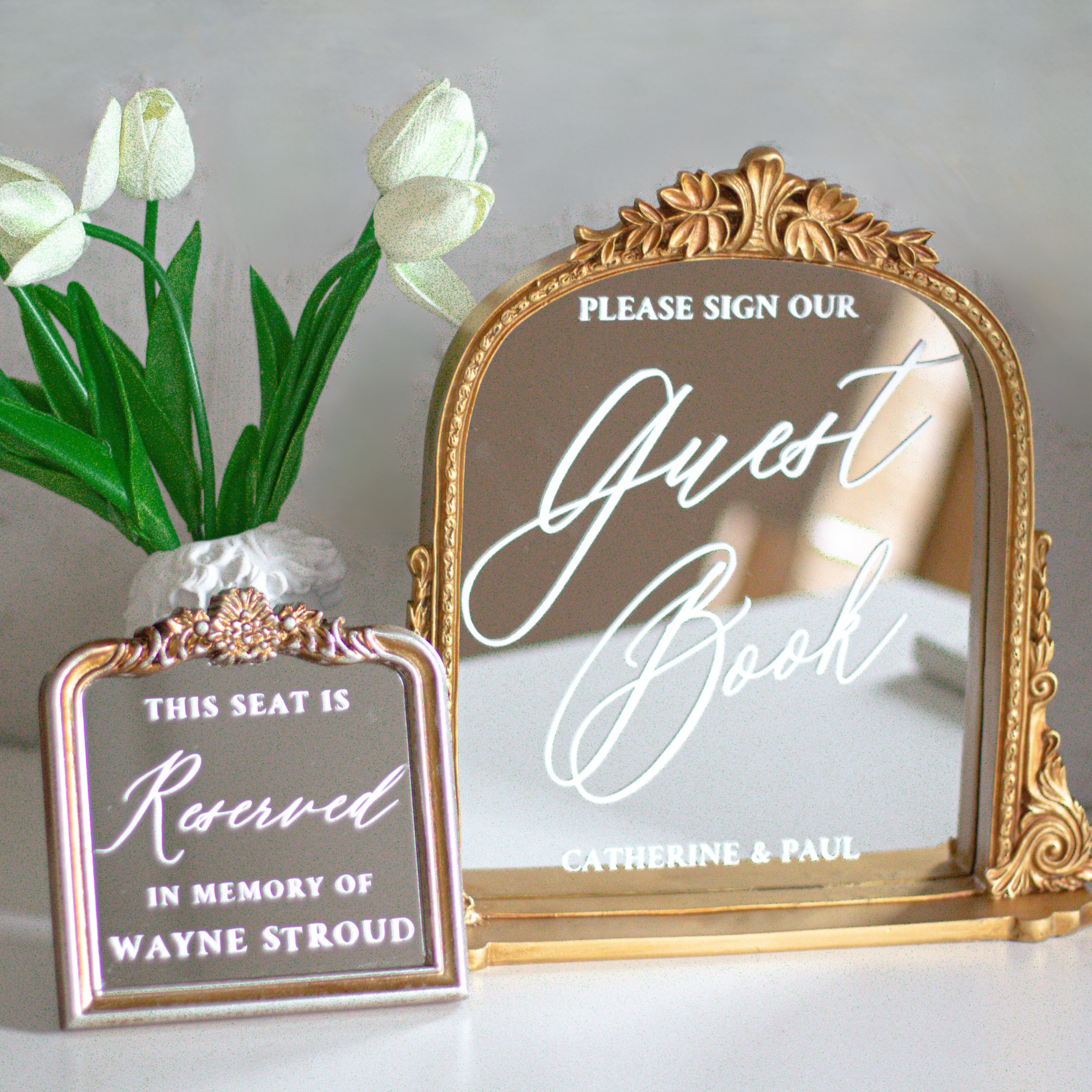 Elegant wedding guest book sign with calligraphy on a gold framed mirror.