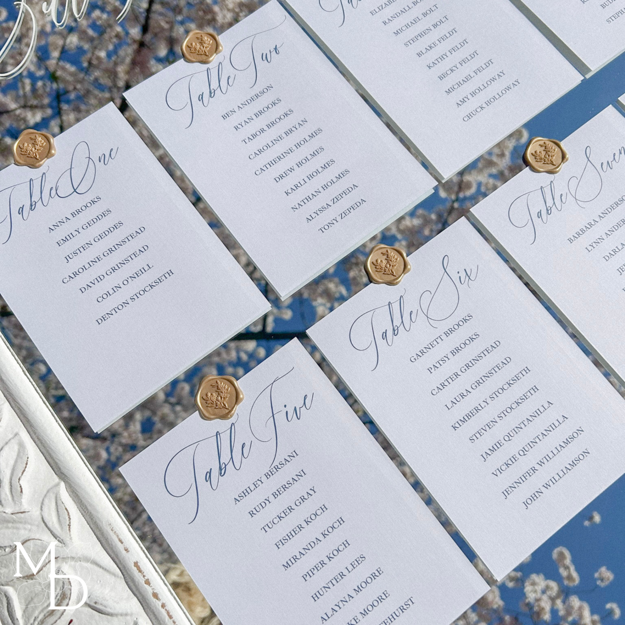 Boho wedding guest seating chart on large white mirror with elegant cardstock and gold wax seals.