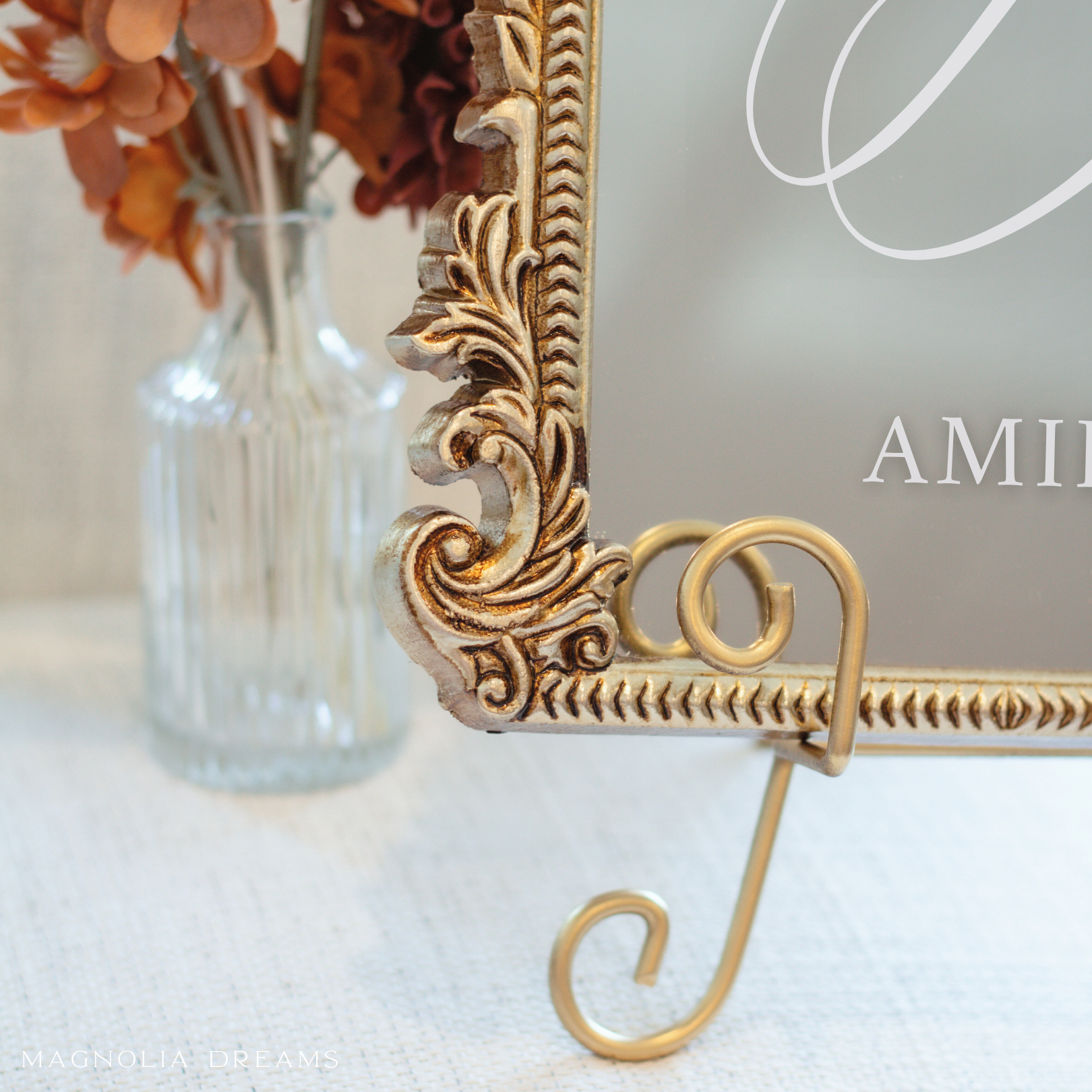 Elegant guest book mirror sign on decorative stand for wedding table display.