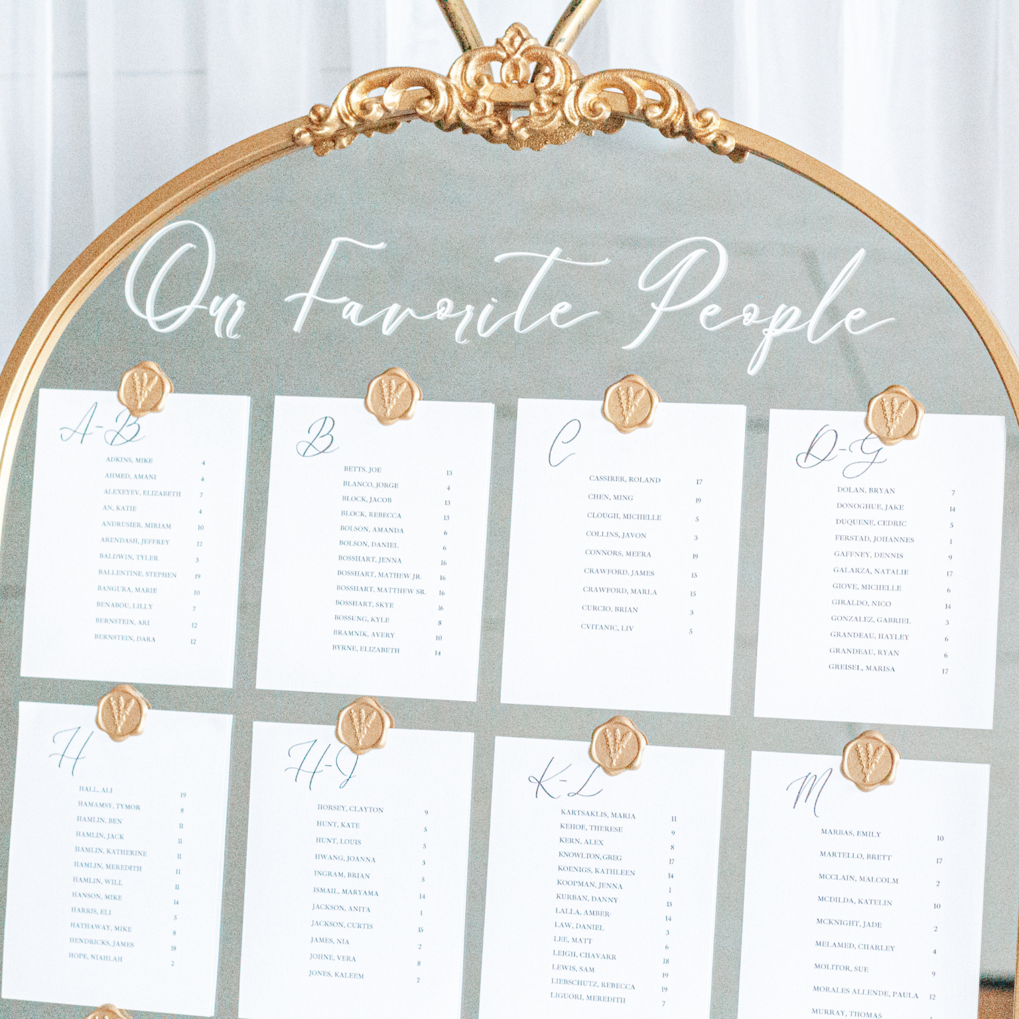 Wedding mirror sign with elegant seating chart and decorative gold trim.