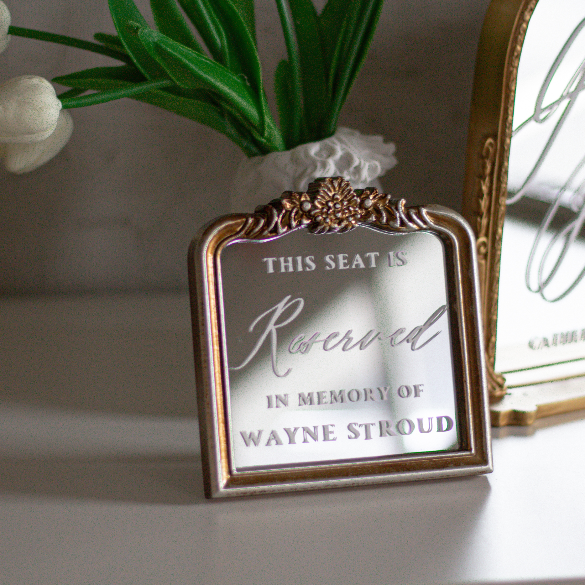 In loving memory wedding sign with custom text on decorative mirror frame.