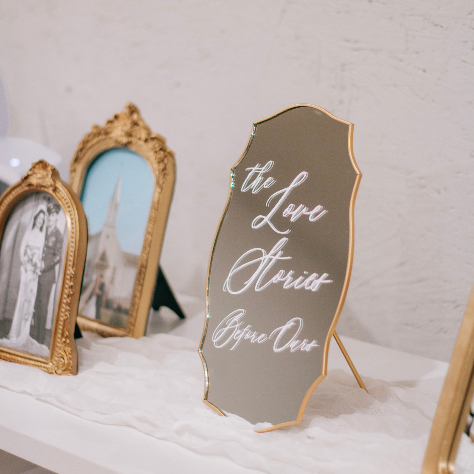 Wedding Memory Sign mirror with "The Love Stories Before Ours" text, surrounded by vintage photo frames.