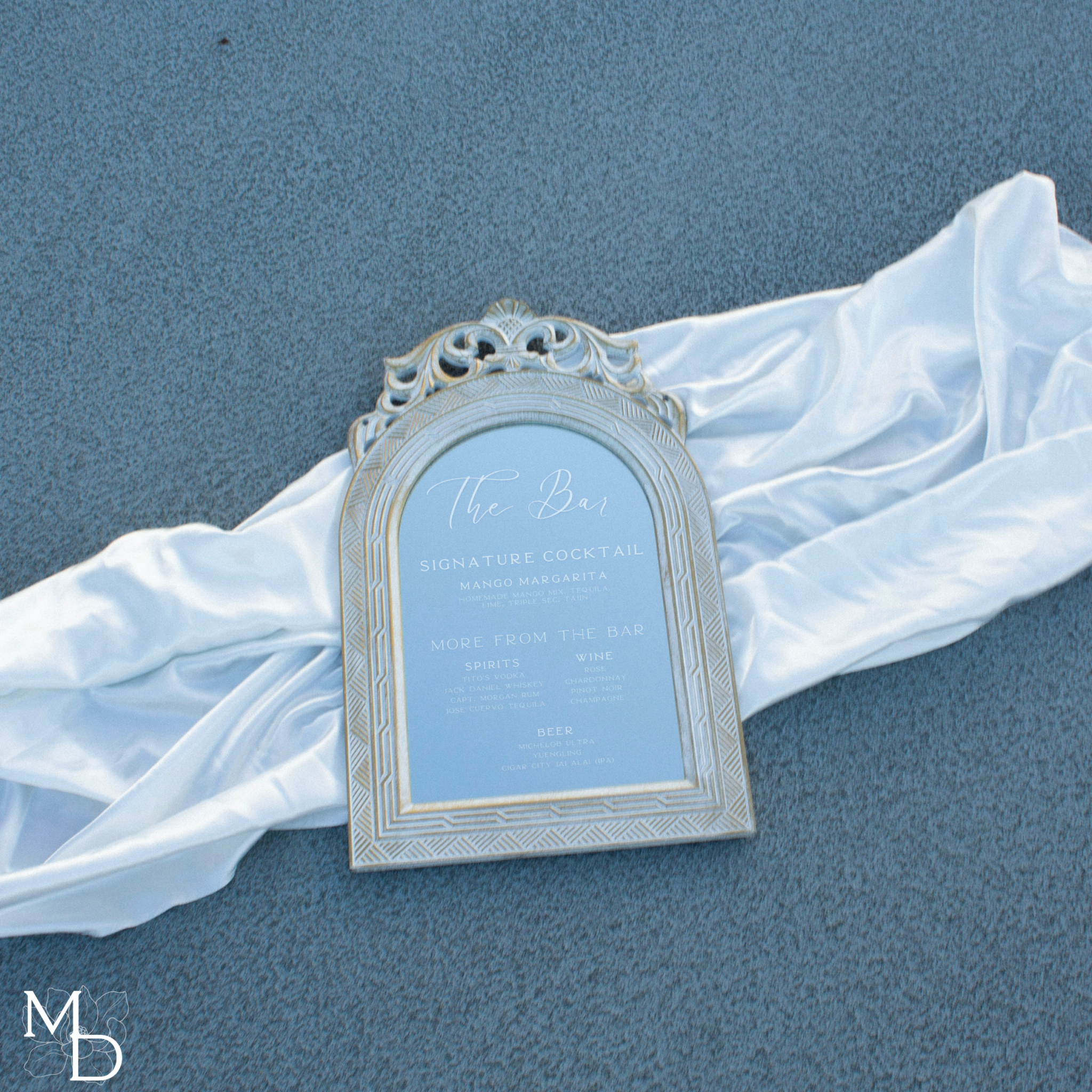 Rustic white mirror with custom wedding cocktail bar menu display.