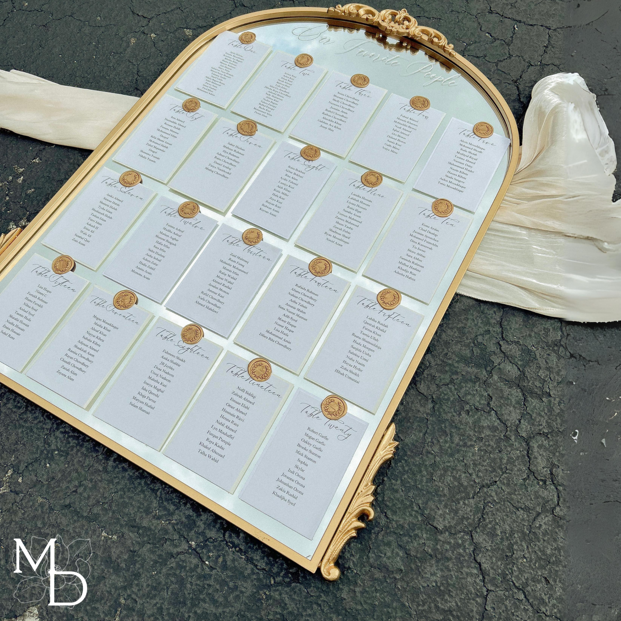 Elegant gold arch mirror wedding seating chart with custom vinyl decal and wax seal design.