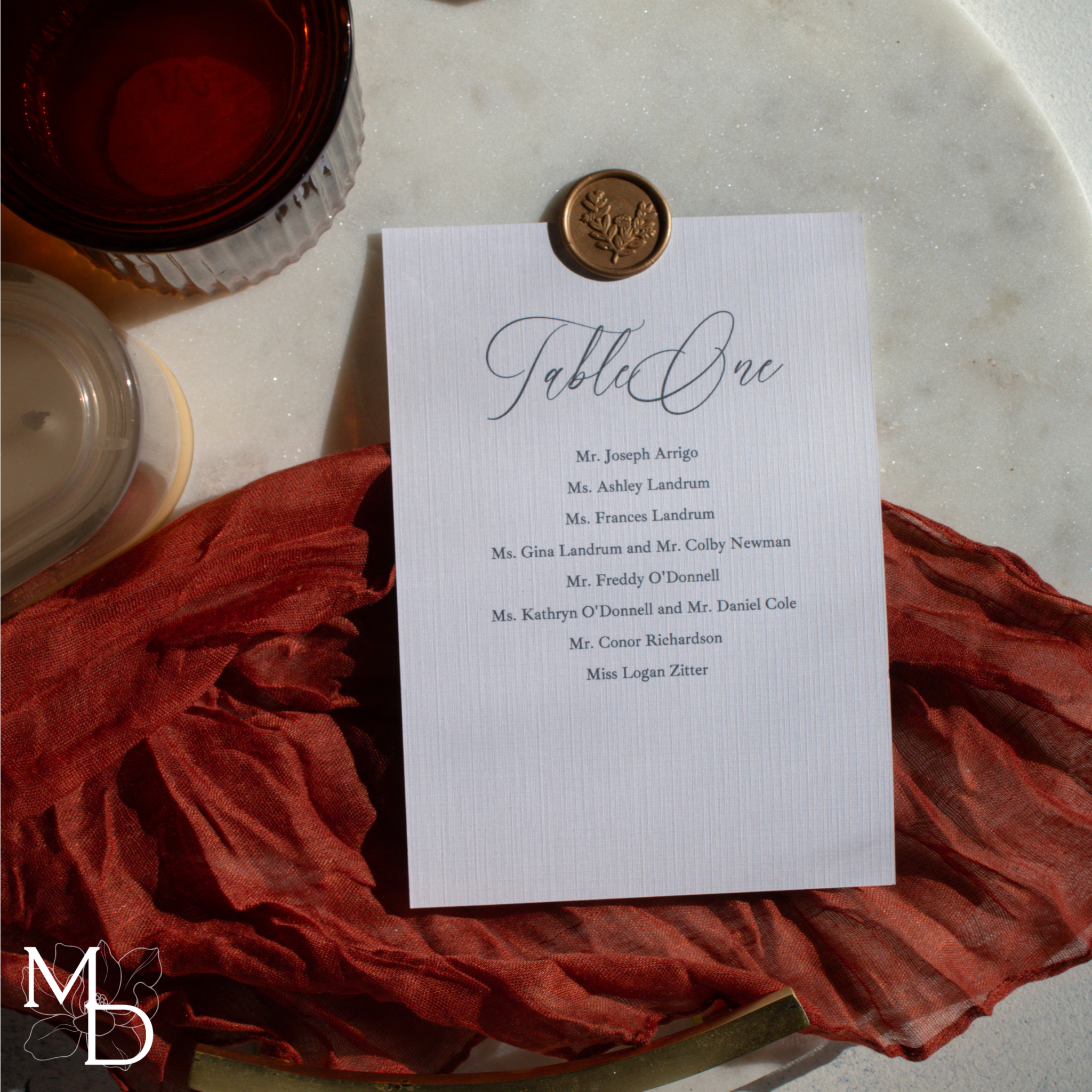 Elegant wedding seating chart assignments card with wax seal on linen cardstock.