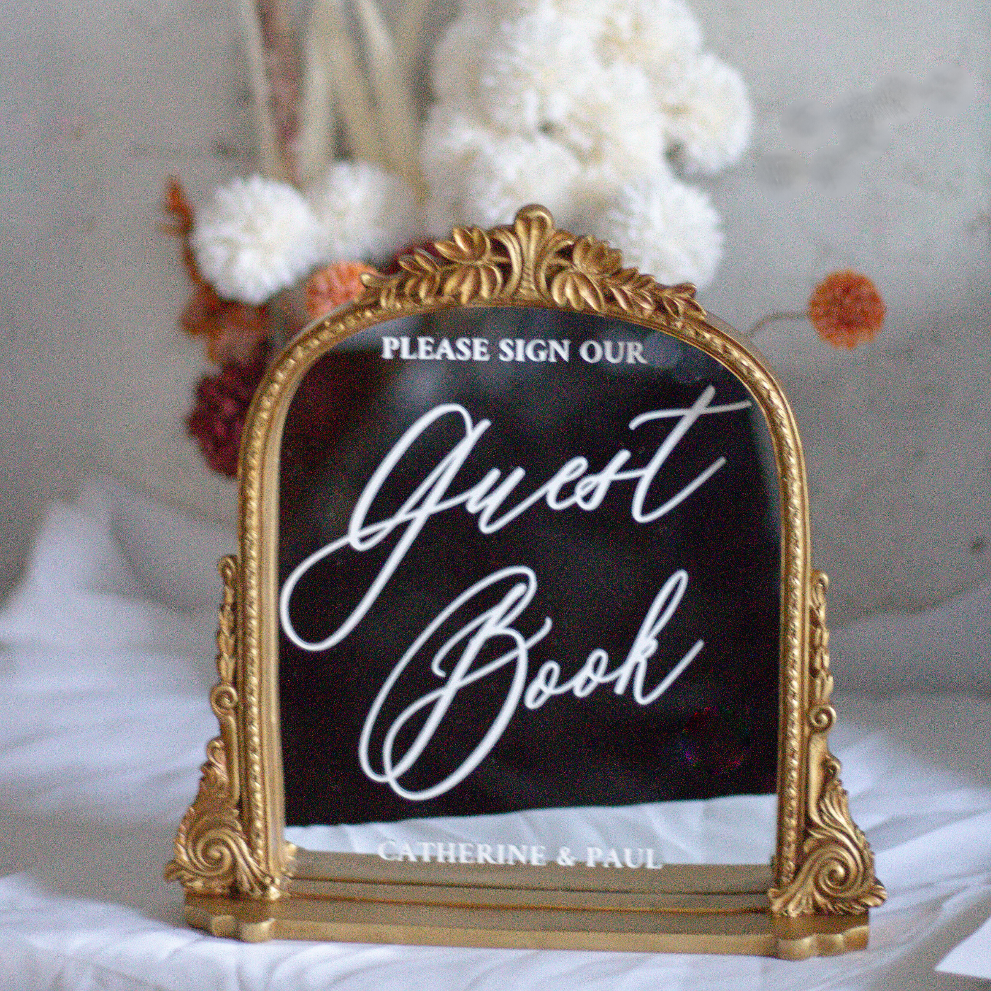 Elegant wedding guest book sign with gold frame and calligraphy font.