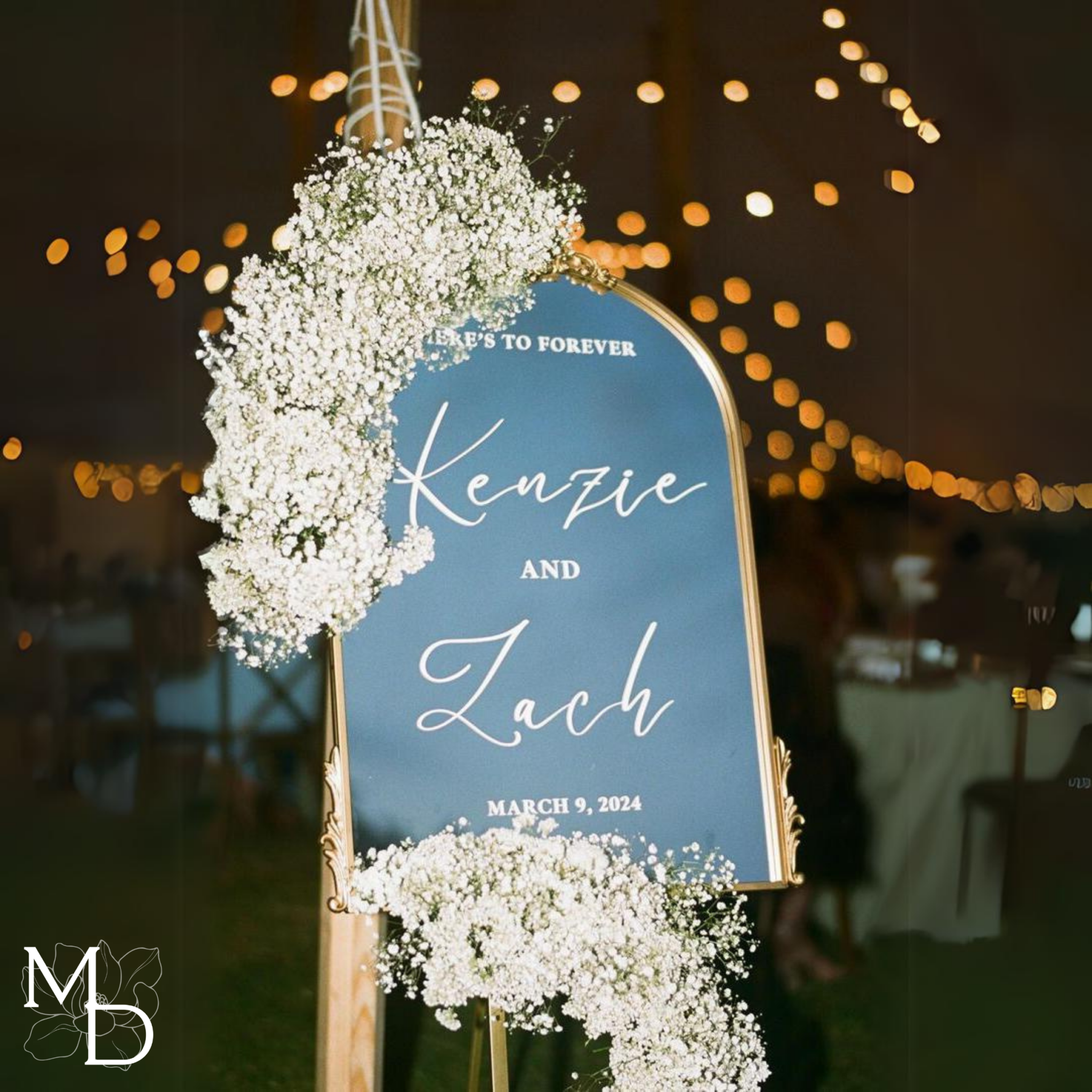 Elegant gold arch mirror wedding welcome sign with floral decoration and custom text.