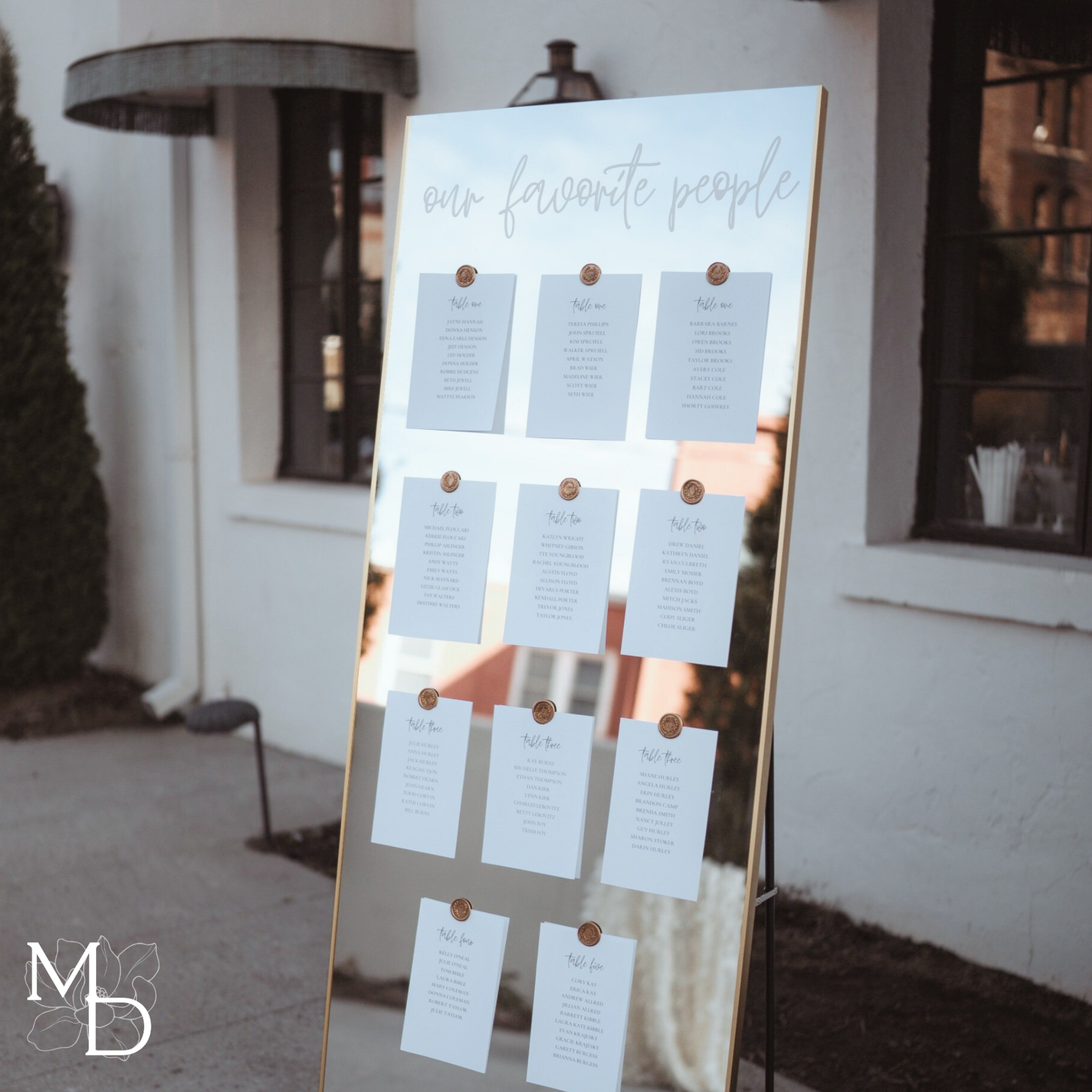 Custom gold mirror wedding seating chart with vinyl decal and wax seals for guest assignments.