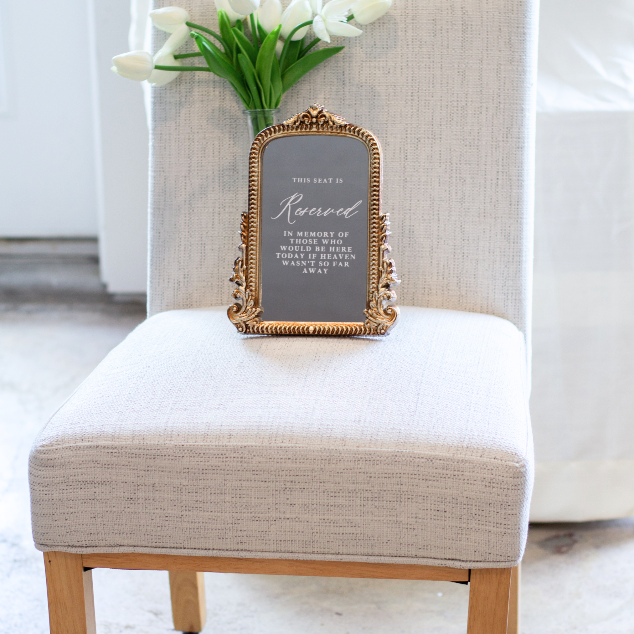 In Loving Memory wedding sign with ornate frame on chair.