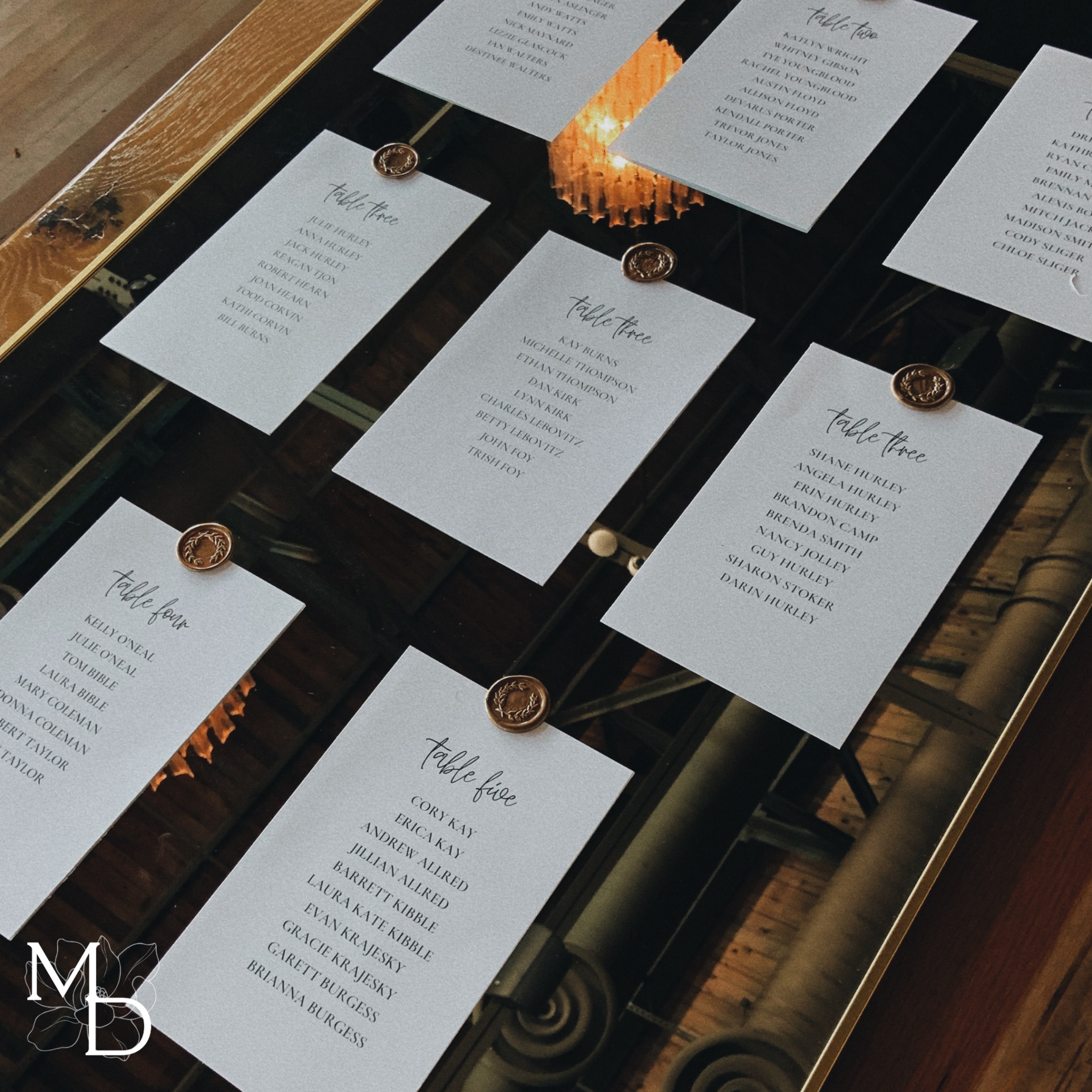 Customized gold mirror wedding seating chart with wax seal options and transportable stand.