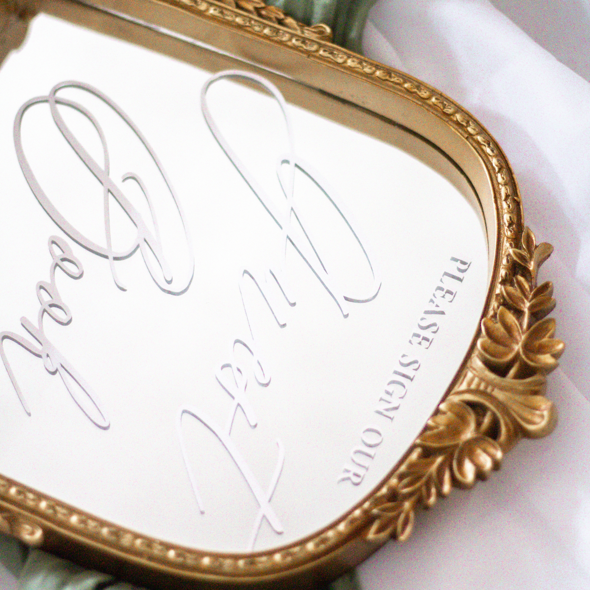 Elegant mirror wedding guest book sign with calligraphy in a decorative frame.