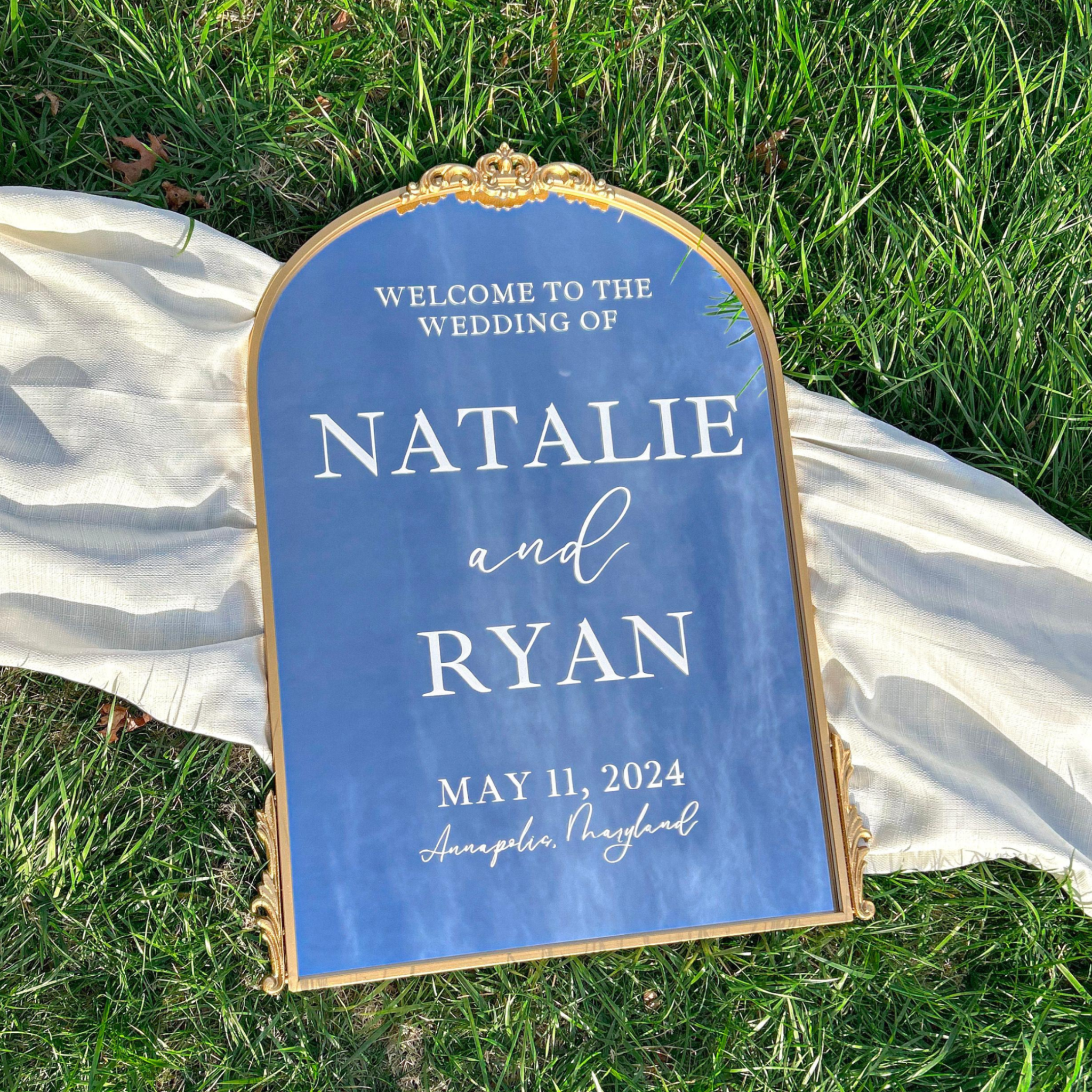 Wedding mirror sign with customizable text on a grassy background.