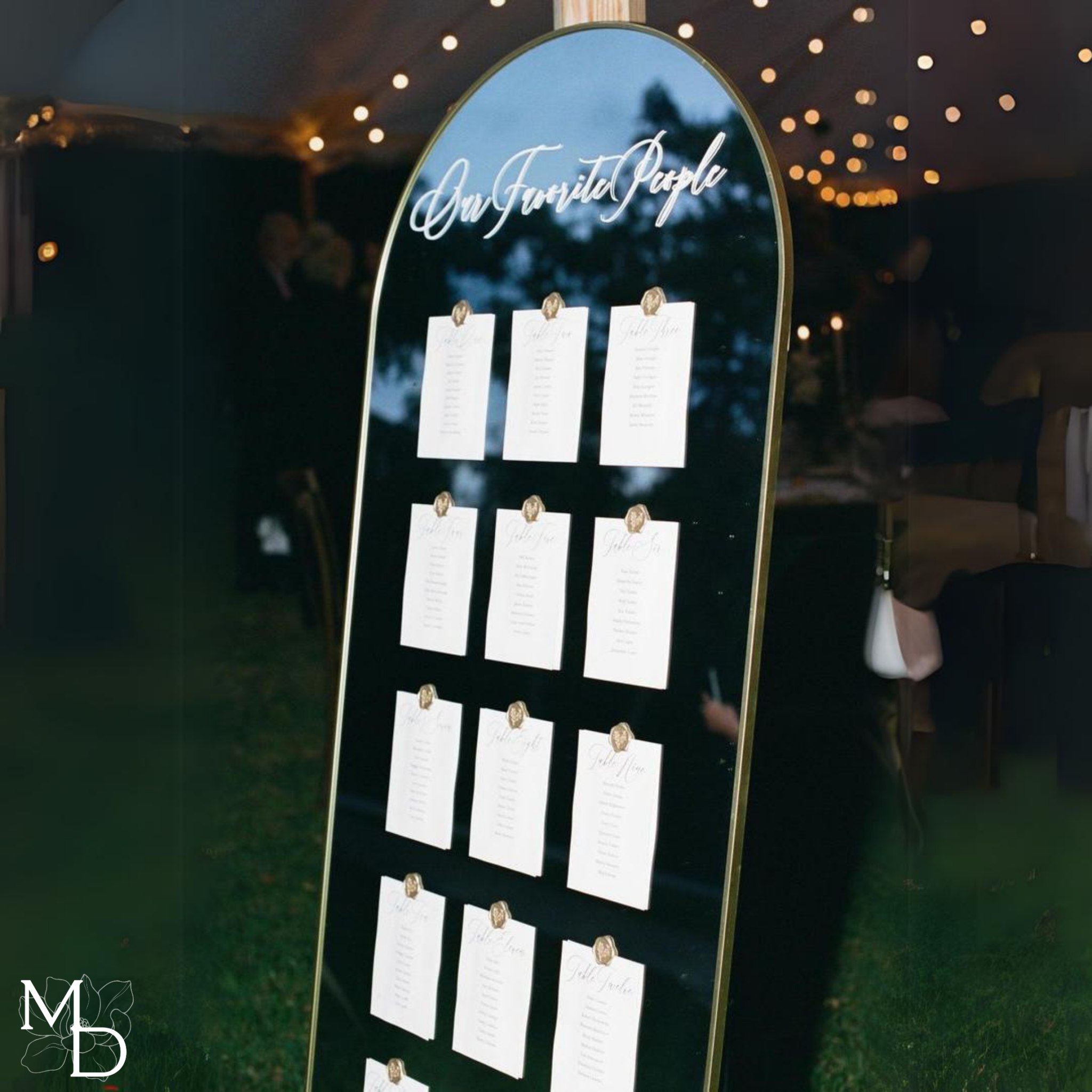 Wedding table seating chart on large gold arch mirror with personalized vinyl decal and linen cardstock cards.