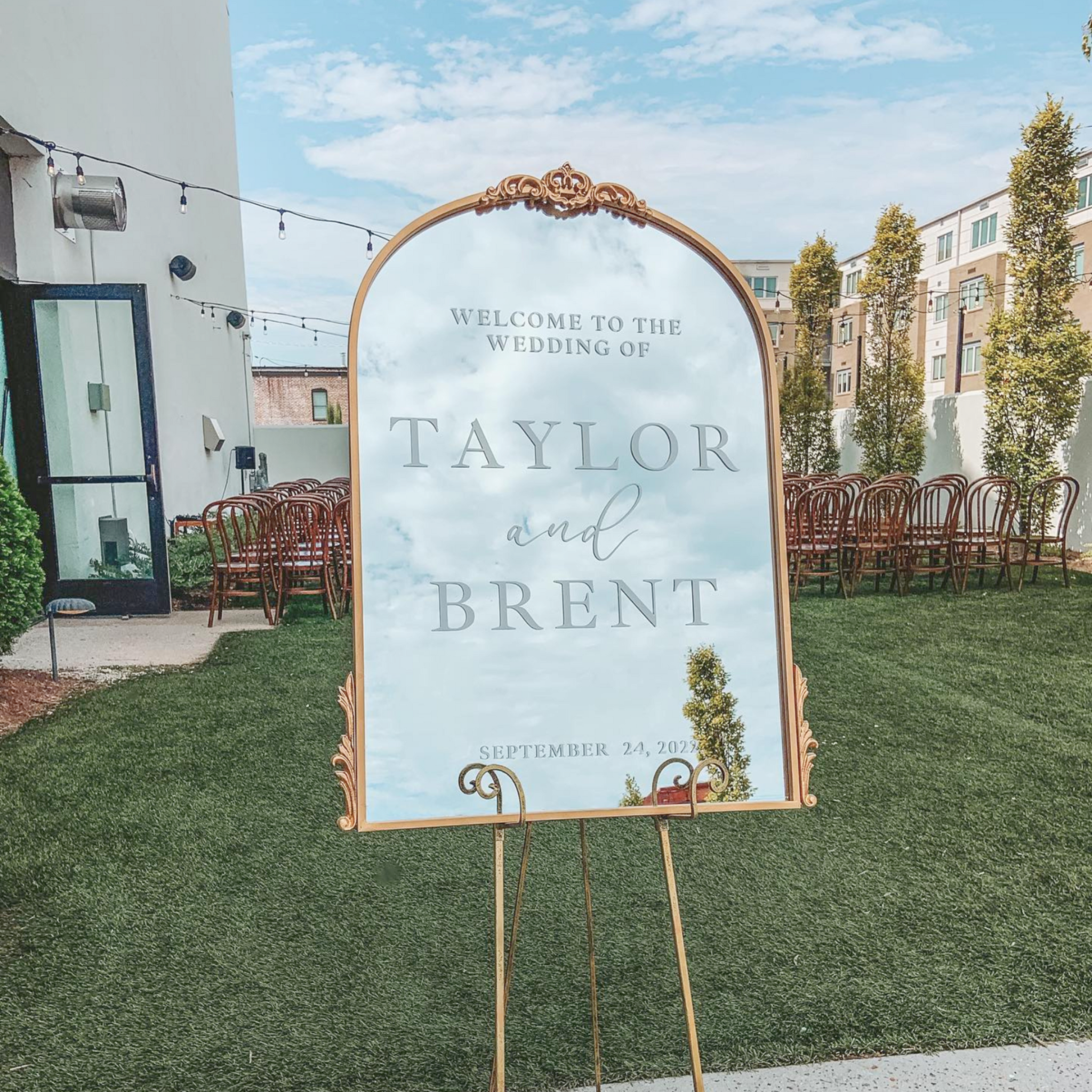 Wedding Sign + Cocktail Mirror Signage Bundle with personalized welcome mirror in outdoor setting.