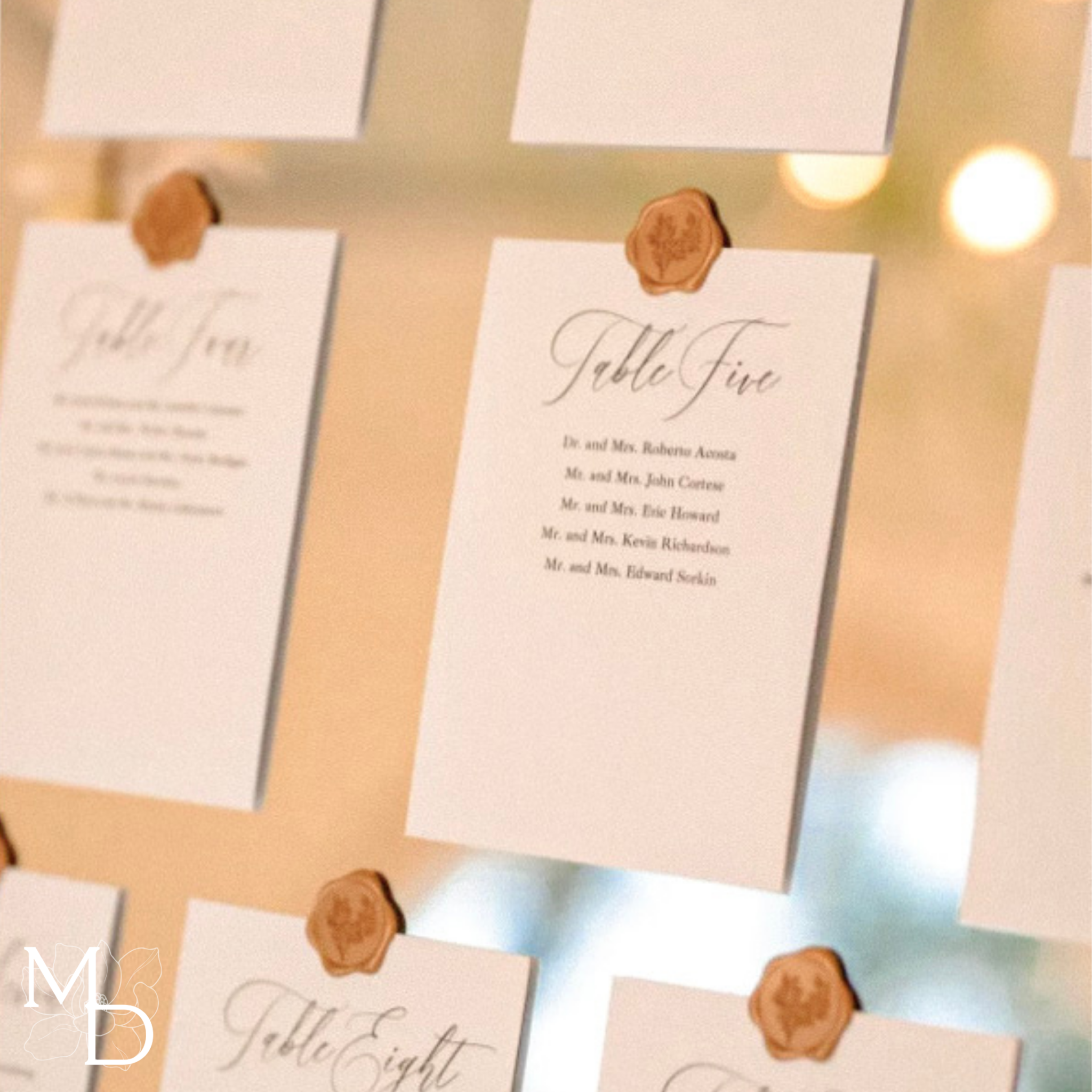 Elegant wedding seating chart assignment cards with decorative wax seals on linen cardstock.