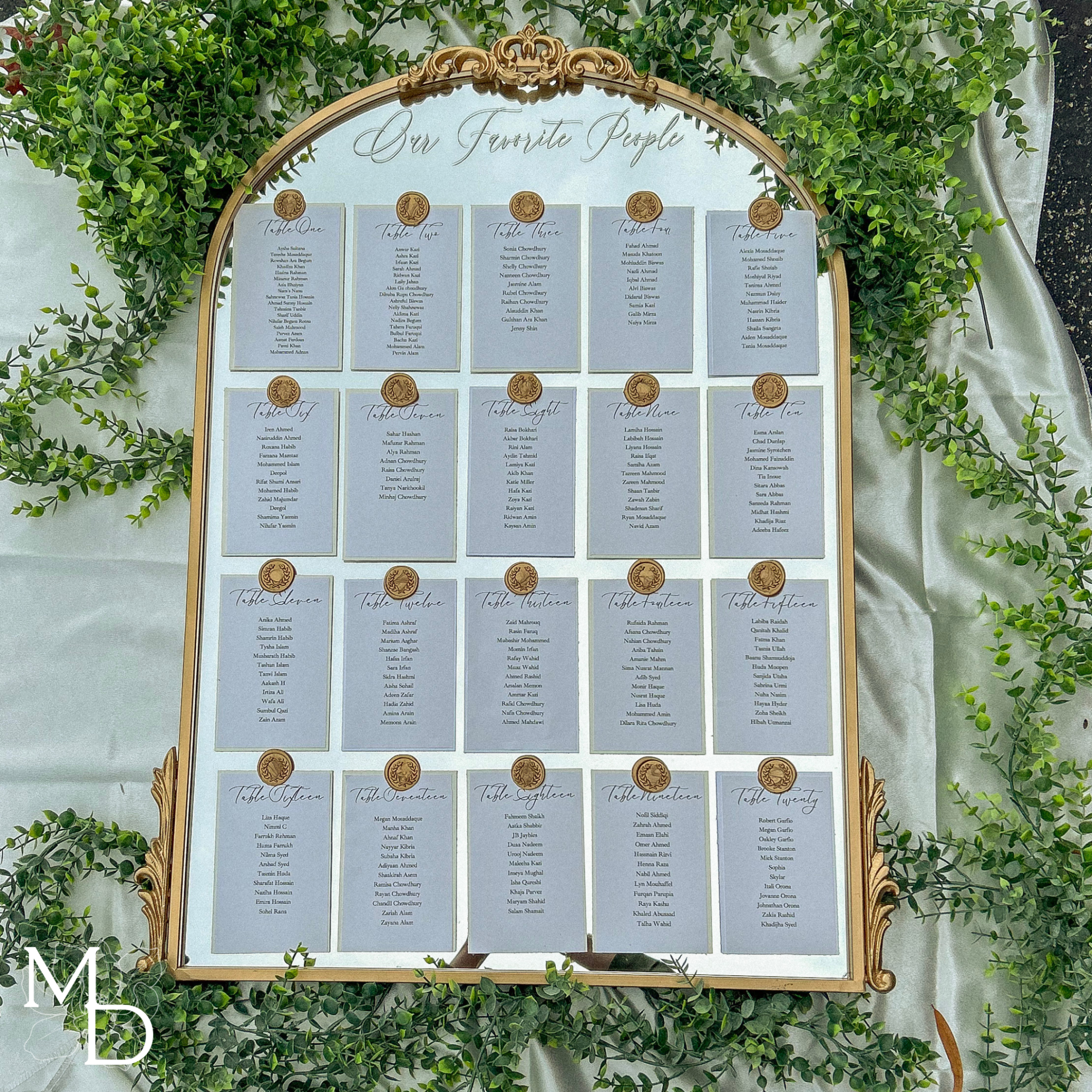 Elegant wedding guest seating chart on gold arch mirror with custom vinyl decal and wax seals.