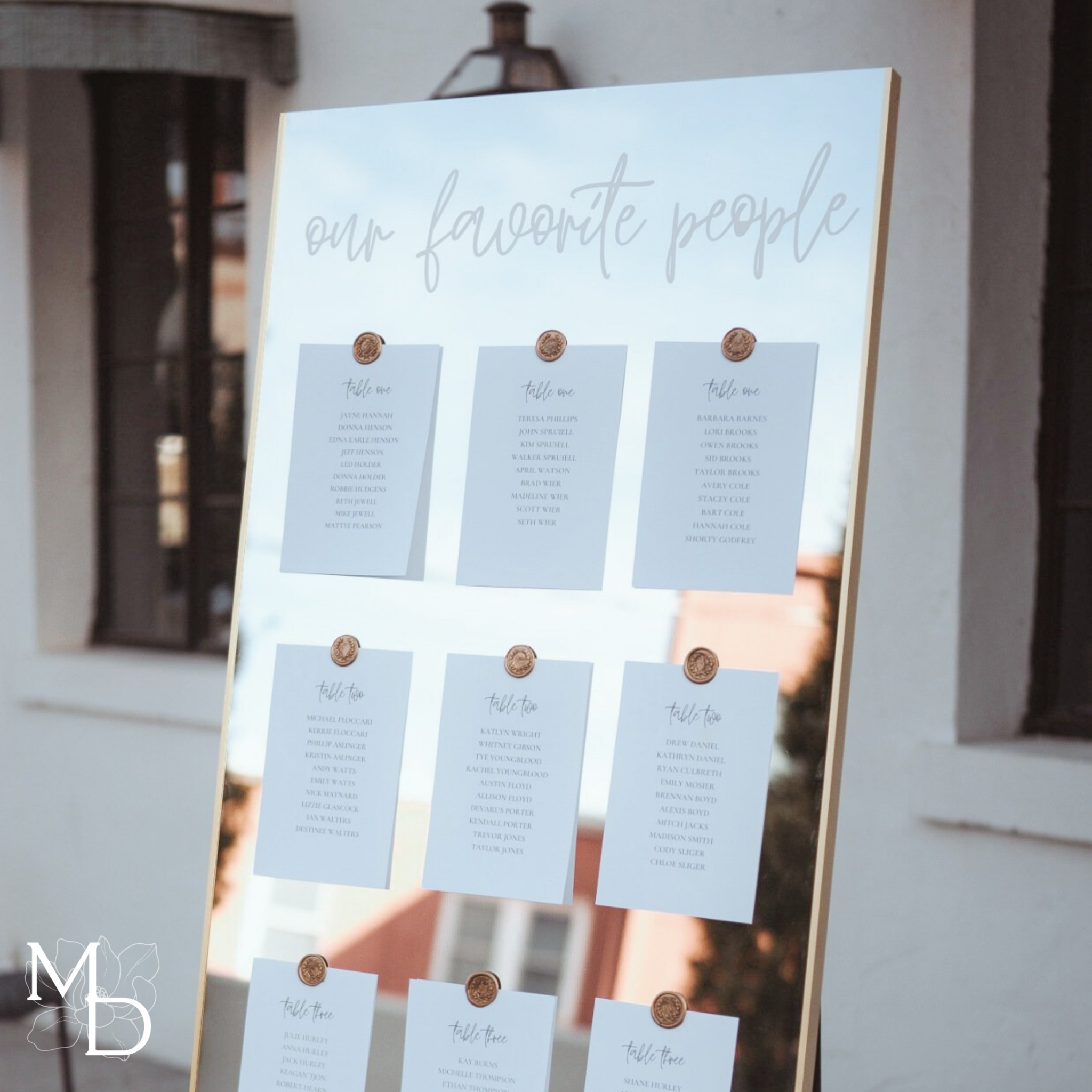 Customized wedding seating chart on large gold mirror with wax seal decorations.