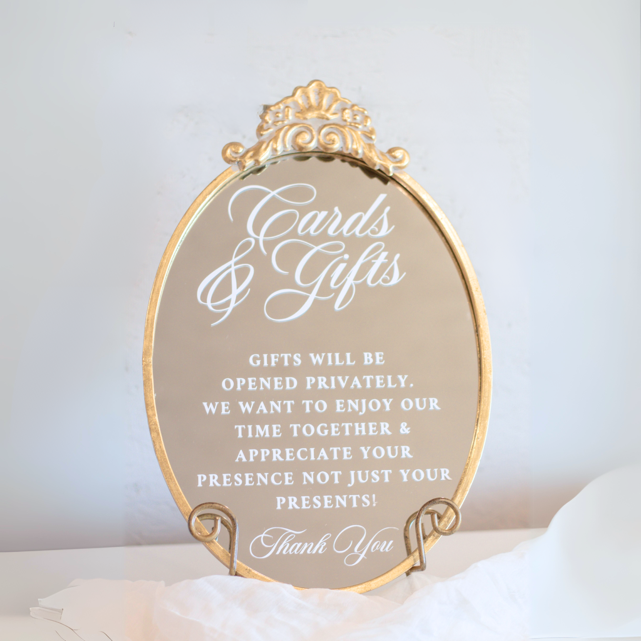 Elegant oval mirror wedding sign with gold fleuron for cards and gifts table.